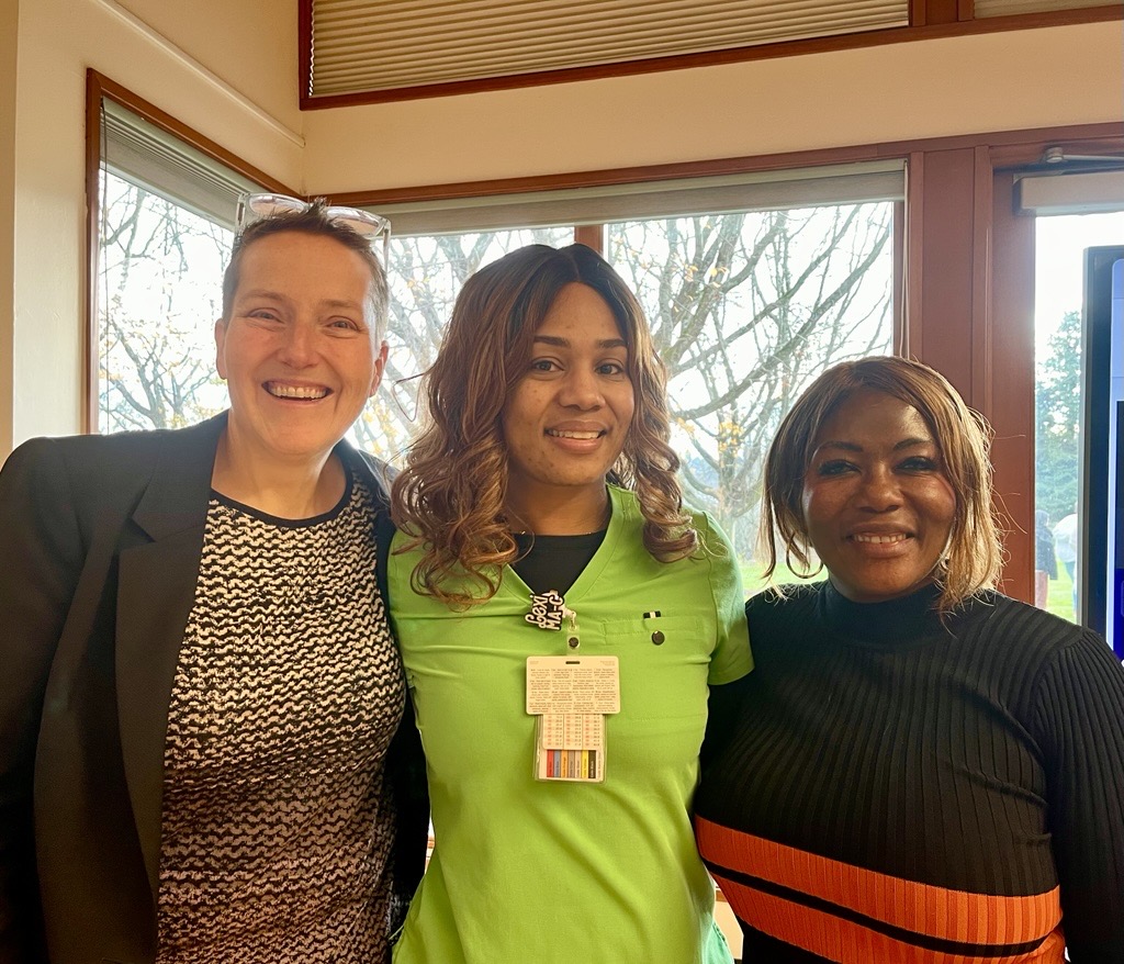 Lexi in bright green scrubs with Training Fund Executive Director, Laura Hopkins, and SEIU Healthcare 1199NW President, Jane Hopkinds.